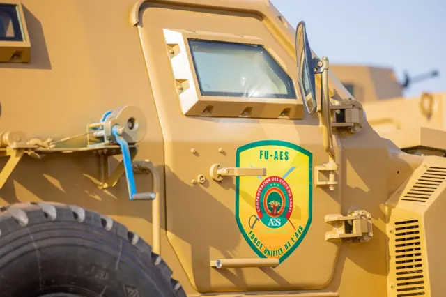 Véhicule militaire jaune avec l'inscription FU-AES, symbole de la force unifiée des trois États du Sahel